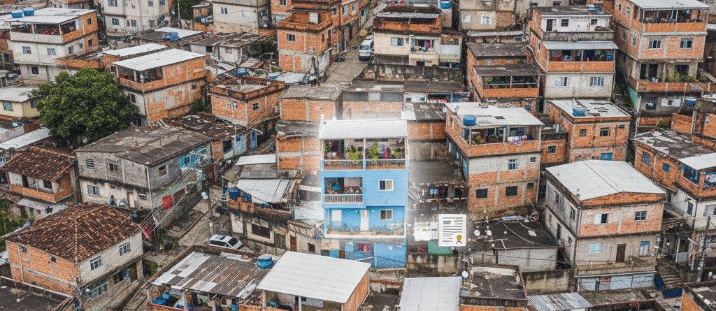 Vista aérea de comunidade com construções sobrepostas, ilustrando o conceito de direito real de laje e regularização de puxadinhos.