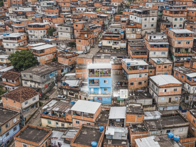 Vista aérea de comunidade com construções sobrepostas, ilustrando o conceito de direito real de laje e regularização de puxadinhos.